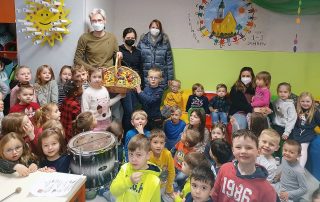 Die Mädchen und Jungen des katholischen Kindergartens „Johannes M. Vianney“ mit Leiter Sebastian Reil (hinten l.) und Erzieherin Svenja Horn (hinten, 4. v. r.) freute sich über den Besuch der FU-Vertreterinnen Ramona Wagner (hinten Mitte) und Gabi Frank (hinten r.).