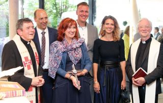 Die Flosser Pfarrer Max Früchtl (l.) und Wilfried Römischer (r.) überreichten nach der Segnung des neuen Bürogebäudes an Harald, Andrea, Ludwig und Sophia Gollwitzer (v. l.) ein zu den Räumlichkeiten passendes modernes Kreuz.