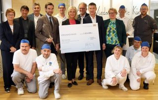 Freude pur bei HPZ-Vorstandsvorsitzenden Christian Stadler (hinten, 4. v. r.), seiner Stellvertreterin Brigitte Krause (hinten l.), HPZ-Prokuristen Michael Gleißner (hinten, 2. v. l.), Aufsichtsratsmitglied Max Hohlrüther (hinten, 3. v. l.) sowie dem Team der Zentralküche: Die Bayerische Sozialministerin Ulrike Scharf (hinten, 6. v. r.) überreichte im Beisein von CSU-Landtagsabgeordneten Dr. Stephan Oetzinger (hinten, 4. v. l.) und dem Irchenriether Bürgermeister Josef Hammer (5. V. r.) den Scheck über die Förderzusage in Höhe von 1,824 Millionen Euro für die Sanierung des „Stockwerke-Hauses“ am Hauptstandort in Irchenrieth. Fotos: St. Landgraf