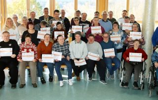 Diese schon lange Jahre in der HPZ-Werkstatt beschäftigten Frauen und Männer sind am Mittwochnachmittag für ihr außergewöhnliches Engagement und ihren Einsatz von der stellv. Vorstandsvorsitzenden Brigitte Krause (l.), von Werkstatt-Fertigungsleiter Reinhard Kagerer (ganz hinten, Mitte), den Aufsichtsräten Daisy Brenner, Helmut Brandl und Max Hohlrüther (ganz hinten, v. l.), sowie von den Mitgliedern des Werkstattrates, Ingo Kraus (r.) und Stefan Beutl (r. im Rollstuhl) ausgezeichnet worden. Foto: Stephan Landgraf